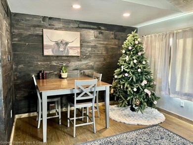 Dining room with wood finished floors, wooden walls, and recessed lighting
