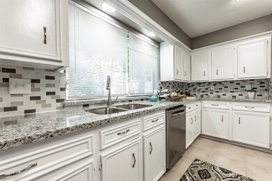 A Kitchen with flat edged granite and custom tile backsplash.  Accented by led lighting.