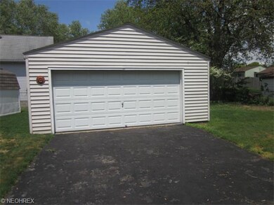 Vinyl sided garage. Blacktop drive.