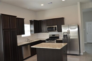 Island Kitchen, SS appliances, Full size Refrigerator, Tiled back splash, SS sink 
 Tiled flooring, open to breakfast area.