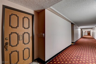 Hallway with a textured ceiling, carpet flooring,