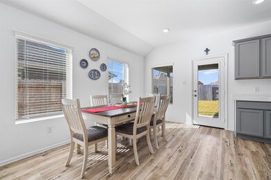 The breakfast area, located next to the kitchen, features multiple windows, and direct access to the backyard, offering a bright and inviting space to start your day.