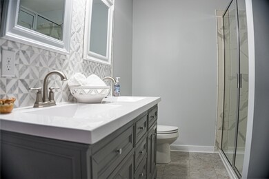 Primary Bath has double vanity and tiled shower. 