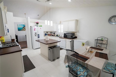 Kitchen featuring white appliances, wood counters,
