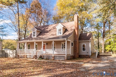 New england style home featuring crawl space, covered porch, a shingled roof, and a chimney