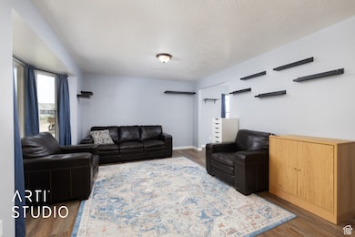 Living area featuring wood finished floors and a textured ceiling