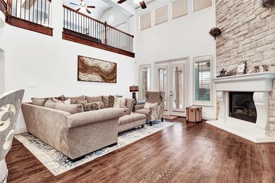 Next you'll step into the family room, resplendent in warm wood tones, a soaring 2 story ceiling, stone gas log fireplace and rows of windows for natural light.