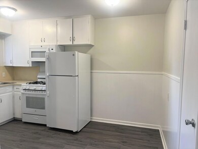 Kitchen with white appliances, dark wood finished