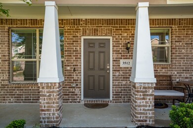Doorway to property featuring covered porch and brick siding