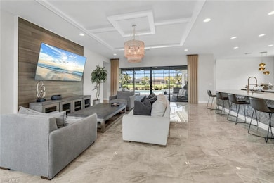 Living room with a notable chandelier, coffered ceiling, and light tile flooring