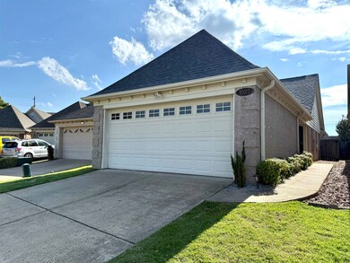 View of home's exterior with roof with shingles, concrete driveway, an attached garage, and brick siding