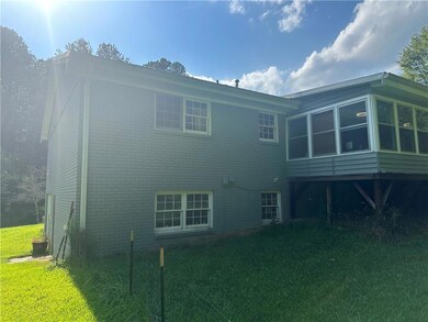 Rear view of property with a lawn, brick siding, a