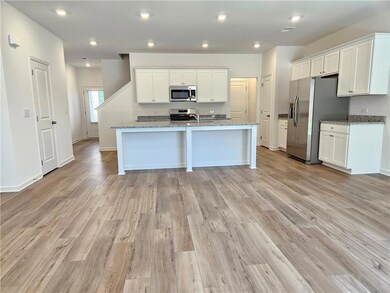 Kitchen with appliances with stainless steel finishes, white cabinetry, light wood-style floors, and recessed lighting