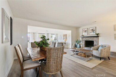 Dining area and living room with stone fireplace.