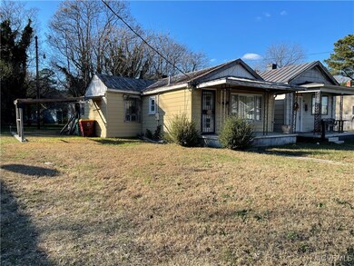 View of front of house with a front yard and a por