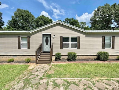 Manufactured / mobile home with crawl space, a front yard, entry steps, and a metal roof