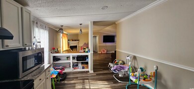 Rec room with crown molding, a fireplace, a textur