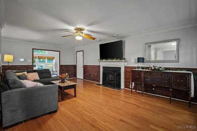 Living room featuring ceiling fan, ornamental molding, and light hardwood / wood-style floors