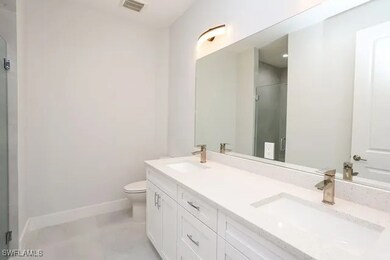 Bathroom featuring vanity, walk in shower, and toi