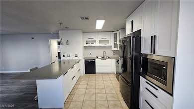 Kitchen with black appliances, a Quartz peninsula,