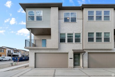 View of front of house featuring a balcony, brick siding, and stucco siding