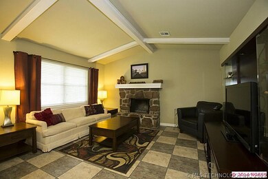 Vaulted and beamed Family Room boasts stone firepl