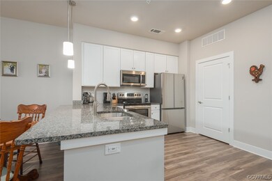 Kitchen featuring dark stone countertops, stainles