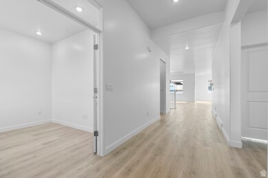 Hall featuring light wood finished floors and recessed lighting
