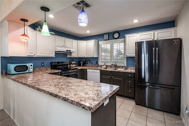 Kitchen with a peninsula, a sink, freestanding ref