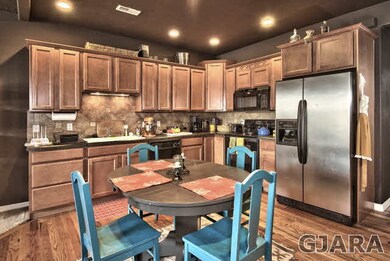 A stainless steel refrigerator and wood floors are