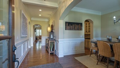 Upon entering into the home, home office is to your left and formal dining to your right.  Gleaming hardwood floors, curved archways and extensive crown molding throughout.