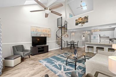 Living room with ceiling fan, a skylight, high vau