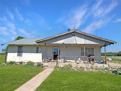 Front view of property with a yard and metal roof. Covered Porch. Beckham County. Sits on 2.5 acres mol.