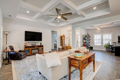 Living room with light wood-style floors, coffered