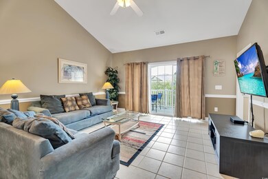 Tiled living room with ceiling fan and high vaulte