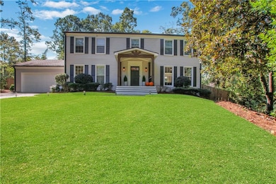 Colonial house featuring concrete driveway and an attached garage