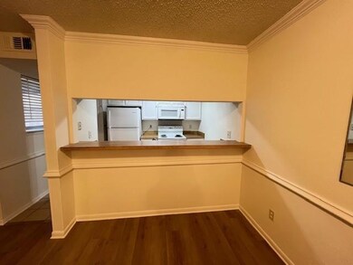 Kitchen with dark wood-style flooring, crown moldi