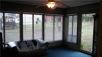 Sun room off from kitchen features plenty of windows...faux wood blinds remain.