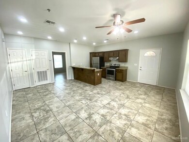 Kitchen featuring electric range, ceiling fan, freestanding refrigerator, recessed lighting, and light stone countertops