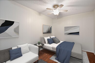 Bedroom with wood finished floors, a textured cei