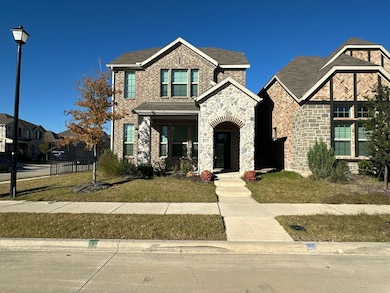 View of front of property with a front lawn, covered porch, brick siding, and stone siding