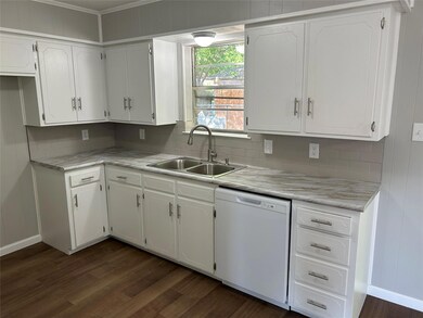 Kitchen with backsplash, dishwasher, white cabinetry, sink, and dark hardwood / wood-style flooring