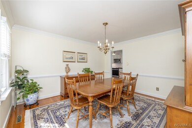 Hardwood floored dining room featuring crown molding and chair rail