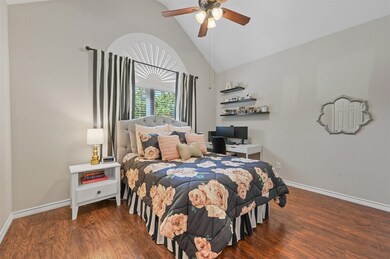 Bedroom featuring Pergo Premium floors, high vaulted ceiling, and ceiling fan