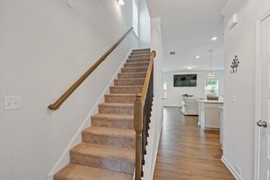 Staircase with wood finished floors and recessed lighting