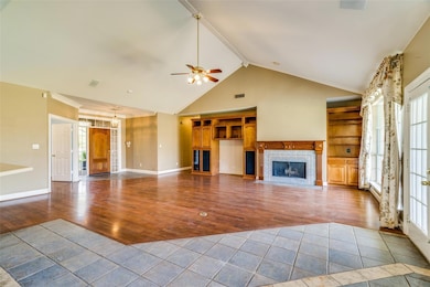 Unfurnished living room featuring ceiling fan, vis