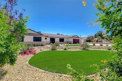 View of front of property with a front lawn, stucco siding, a garage, and brick siding
