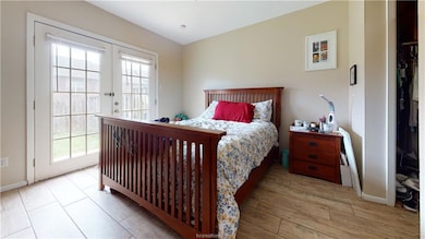 Bedroom with french doors, multiple windows, wood