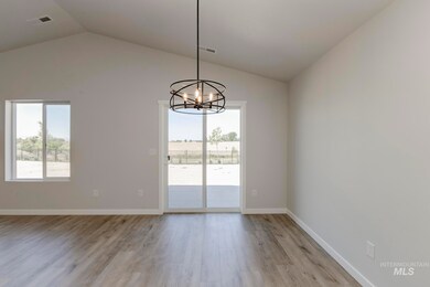 Unfurnished dining area with plenty of natural light, light wood-style floors, vaulted ceiling, and a chandelier