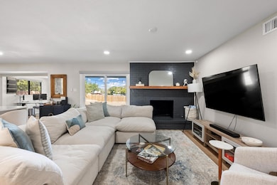 Living area with a fireplace, wood finished floors, and recessed lighting